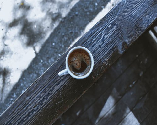 A cup of black coffee on a wooden table